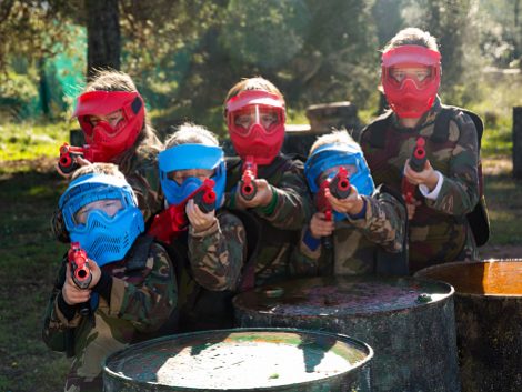 Portrait of sportive kids paintball players wearing uniform and holding guns ready for playing outdoor